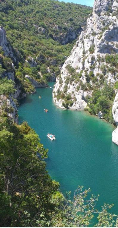 un groupe de bateaux dans une rivière à côté d'une montagne dans l'établissement Mazet provençal Gorges du Verdon 4 personnes, à Saint-Martin-de-Brômes