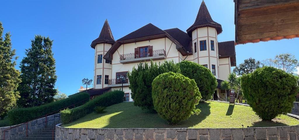 a large house with trees in front of it at Chateau Palace in São Lourenço