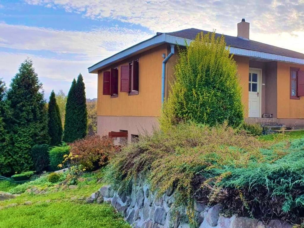 una casa amarilla en la cima de una colina con árboles en Chata Adela, en Svätý Anton