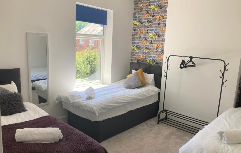 a bedroom with a bed and a mirror and a window at Elite Wolverhampton short/long stays in Wolverhampton