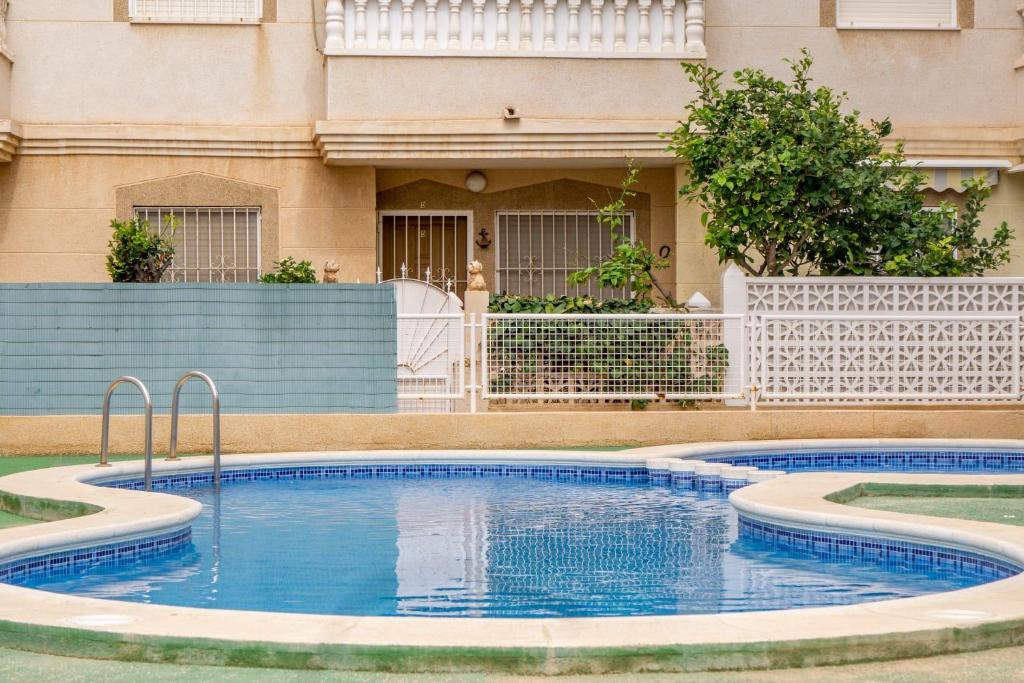 une piscine en face d'un bâtiment dans l'établissement VACATION NEAR THE SEA. (POOL-SHOPS-RESTAURANTS), à Torrevieja