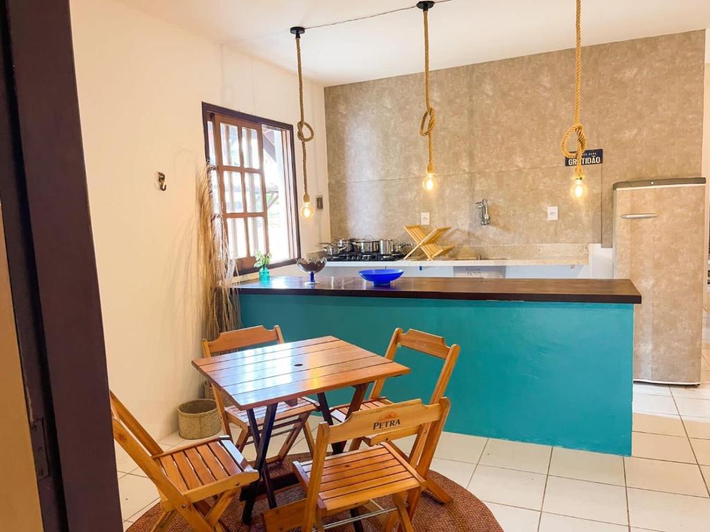 a kitchen with a wooden table and a blue counter at Casa Mar in Praia do Forte
