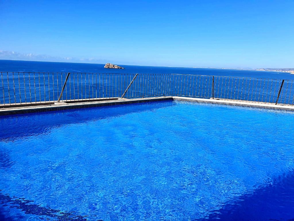 una gran piscina con el océano en el fondo en Spectacular Sea views 2 bedrooms in Villa Marina, en Benidorm