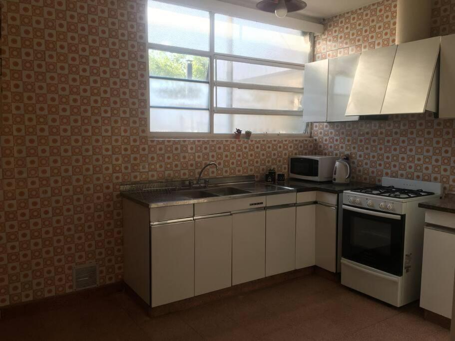 a kitchen with a sink and a stove and a window at Hermosa casa tranquila en la ciudad in Mendoza