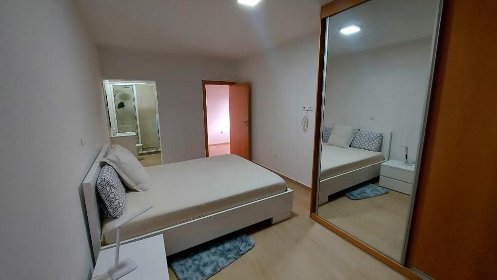 a small bedroom with a mirror and a bed at Apartamento F3, Lazareto - Mindelo in Mindelo