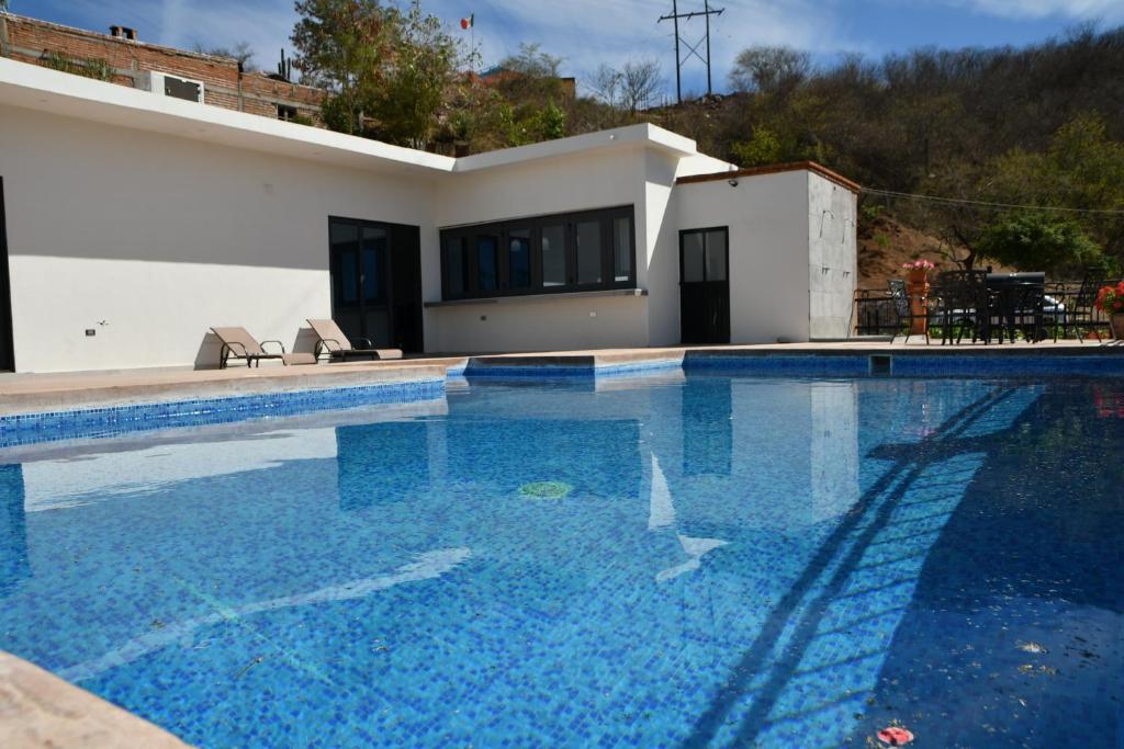 a swimming pool in front of a house at Casa de Cuatro Vientos in Álamos