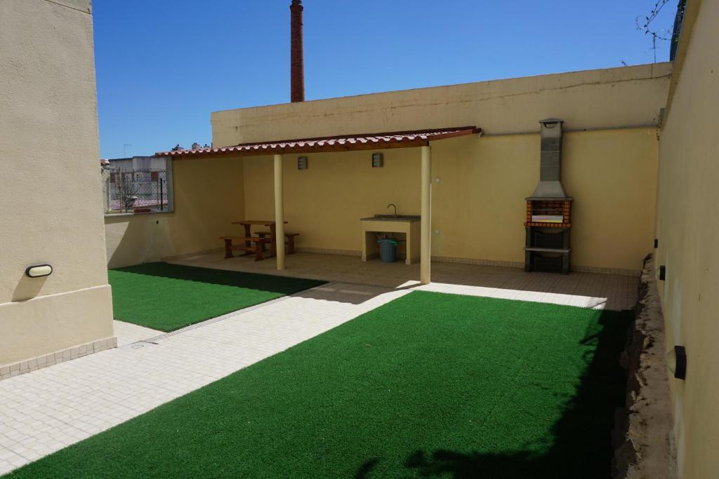 een patio met groen gras aan de zijkant van een gebouw bij Sunny Home in Amadora