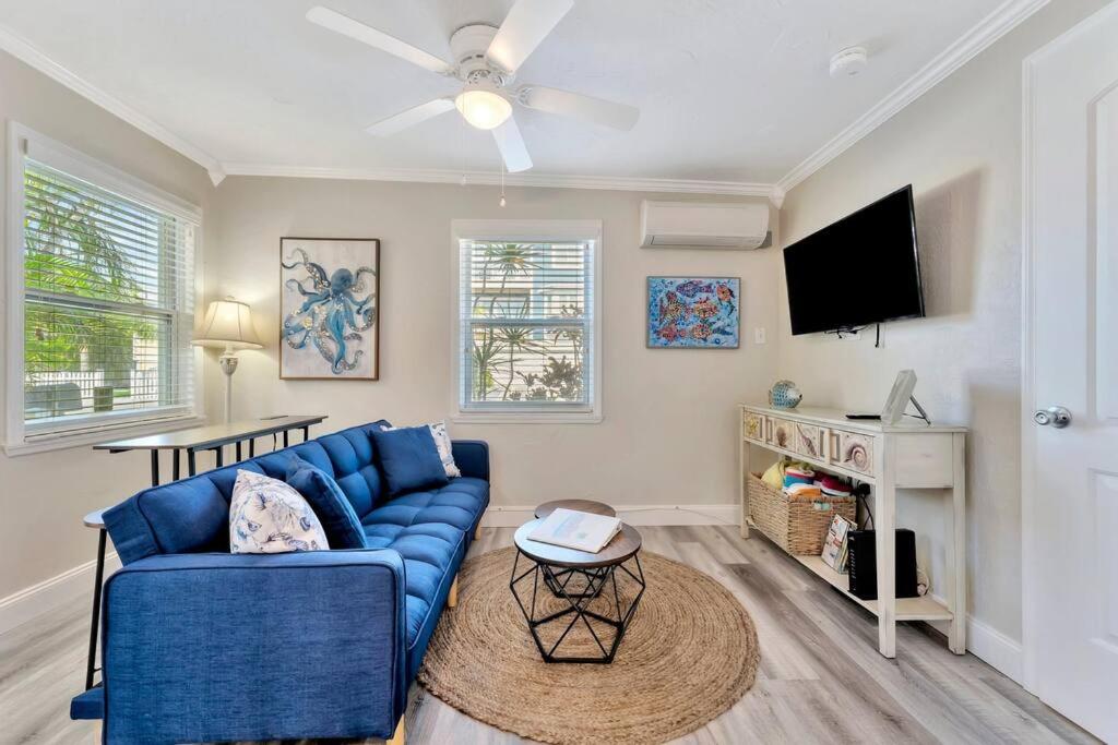 a living room with a blue couch and a tv at Sea Gem One bed one bath charmer steps to beach in Bradenton Beach
