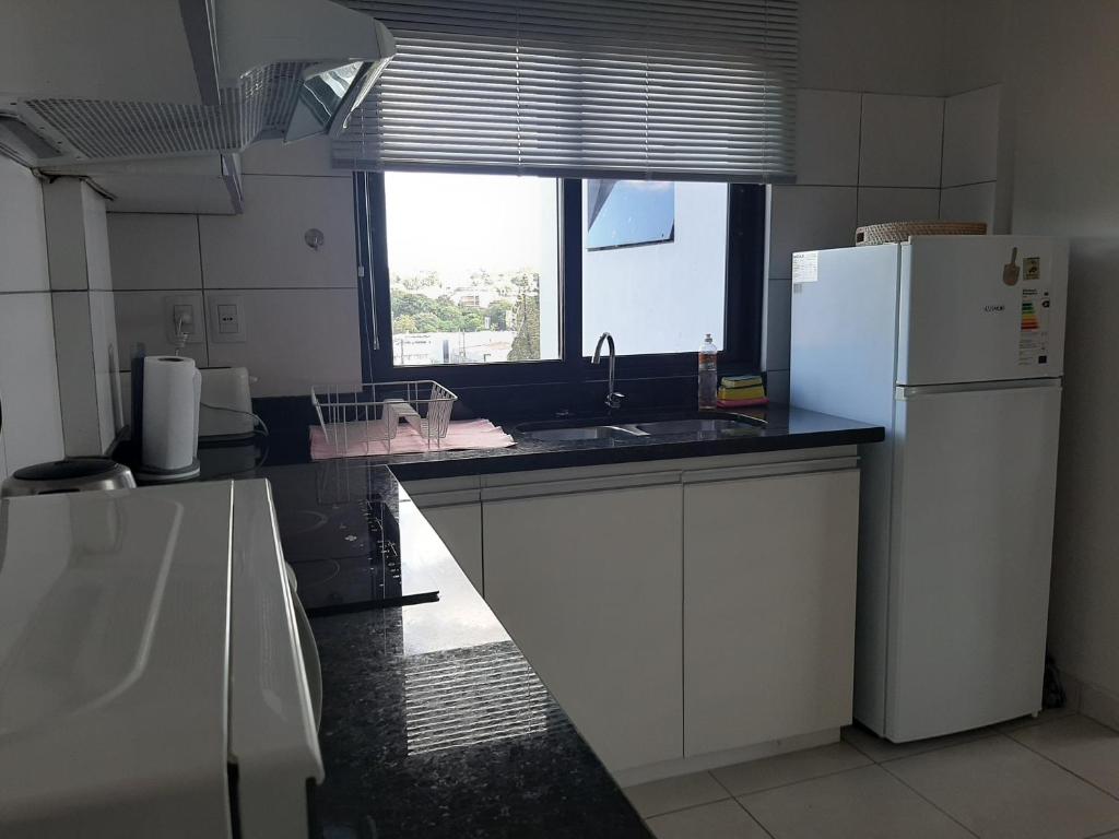 a kitchen with a white refrigerator and a window at Miradores del Chaco in Asuncion