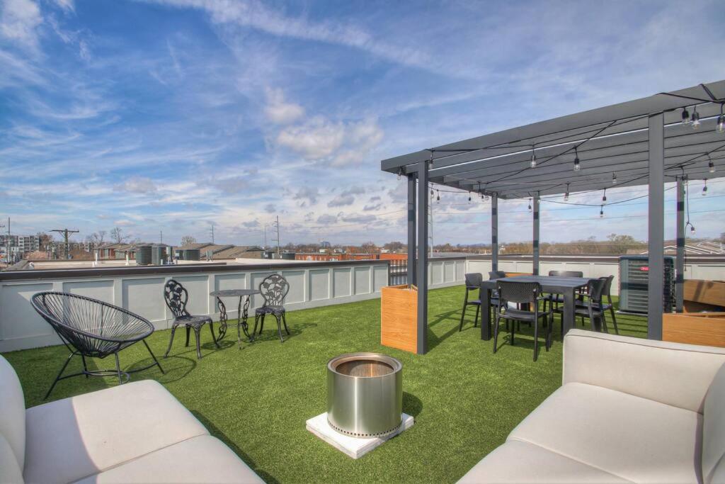 a patio with a table and chairs on a roof at Luxury 3 Level East-Nash Home w/ Rooftop Terrace in Nashville