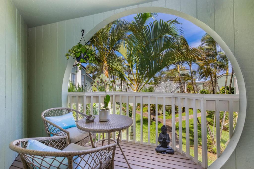 d'un balcon avec une table, des chaises et des palmiers. dans l'établissement Kamahana 16 - up, à Princeville