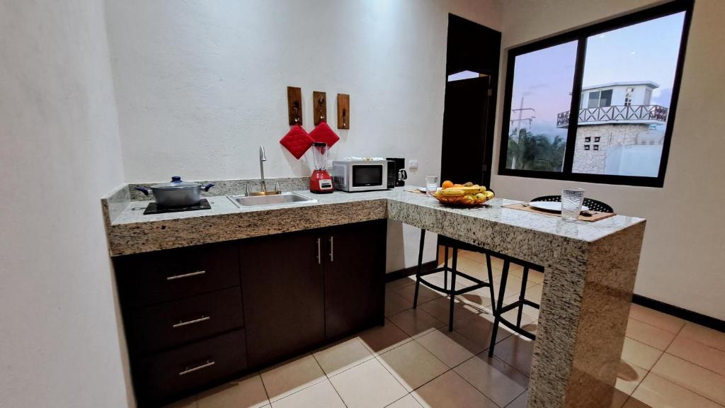 cocina con encimera con fregadero y microondas en Playa Blanca - Moro Blue, en Cancún