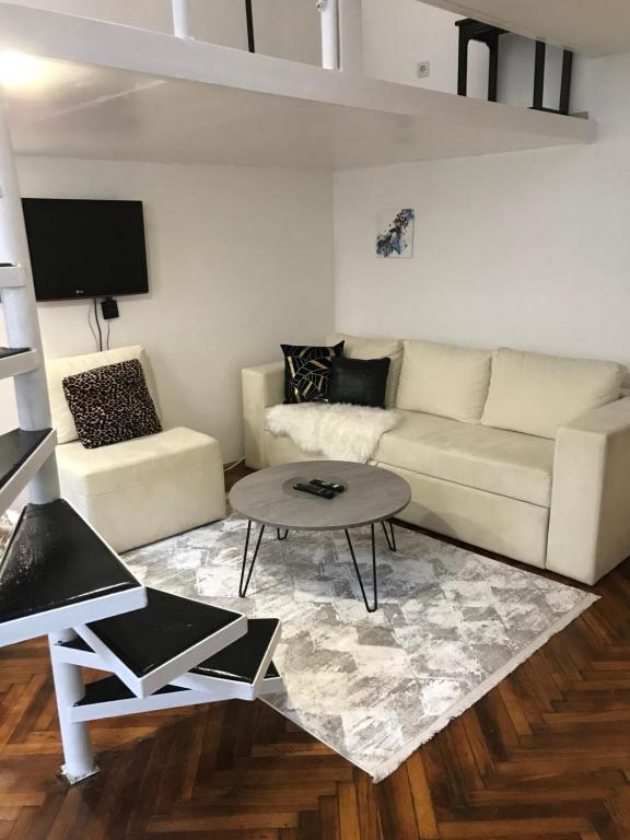 sala de estar con sofá blanco y mesa en Apartment Amra, en Sarajevo