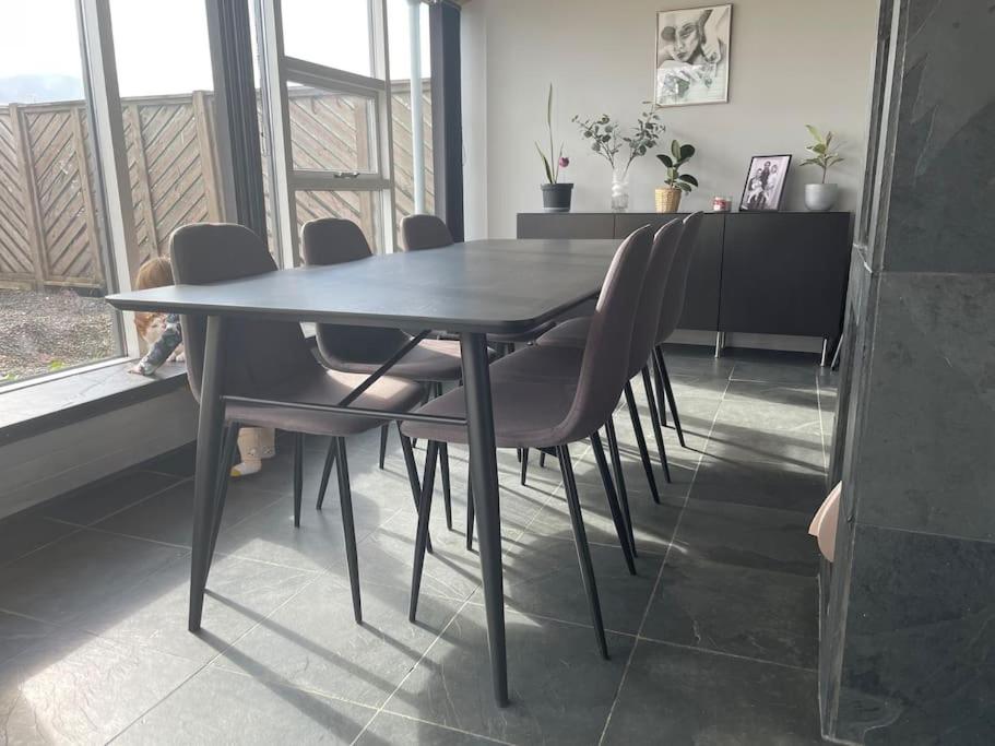 a dining table and chairs in a room with a window at Heiðarbrún in Hveragerði