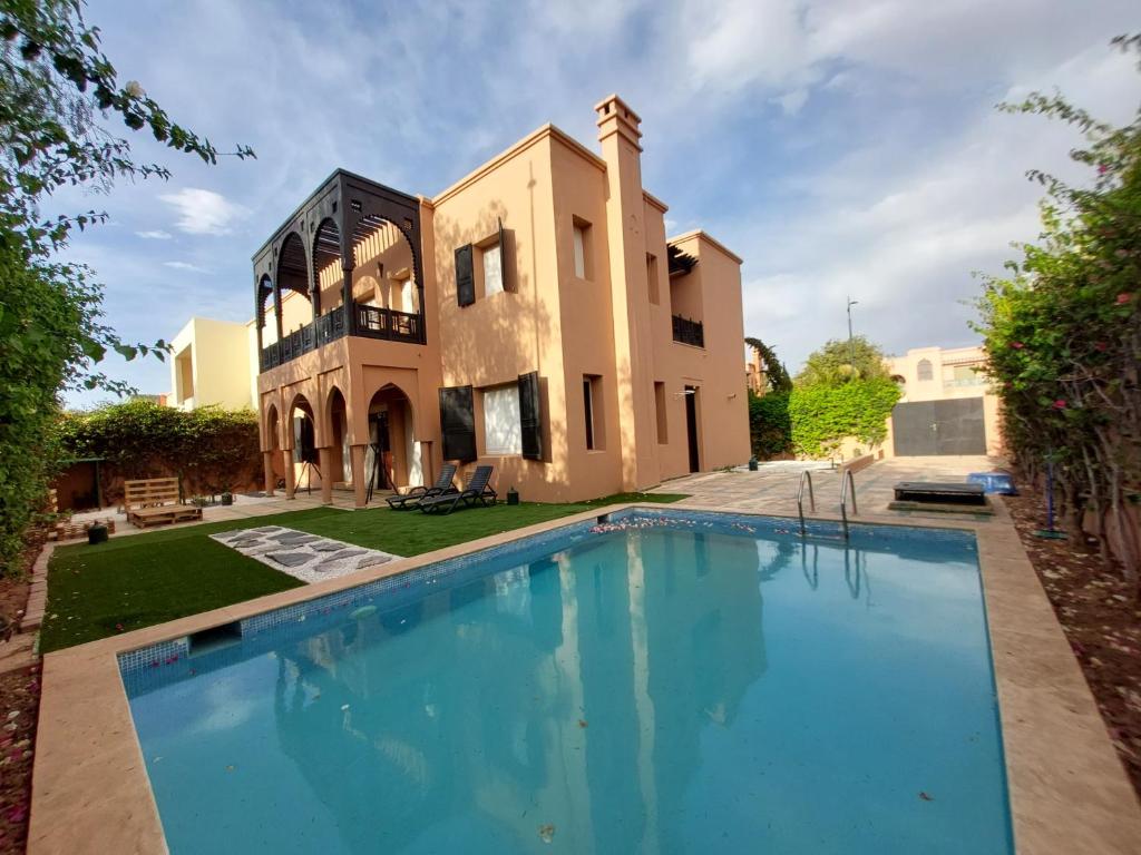 una grande piscina di fronte a una casa di Villa Dahlia a Marrakech