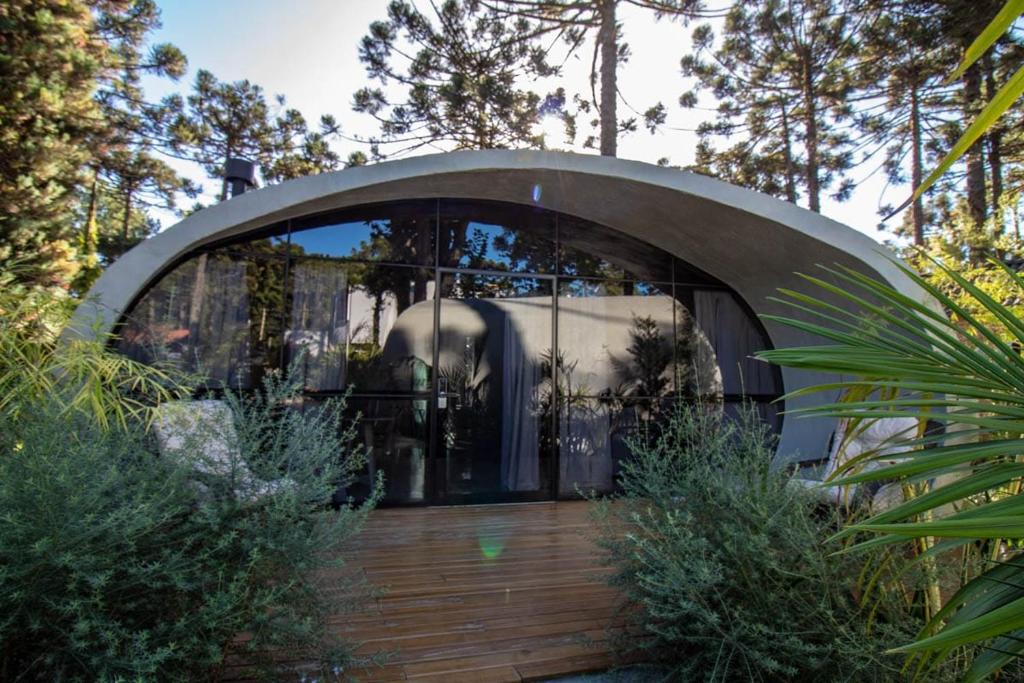 un edificio con una gran ventana en un jardín en Aton Cabanas Boutique, en Canela