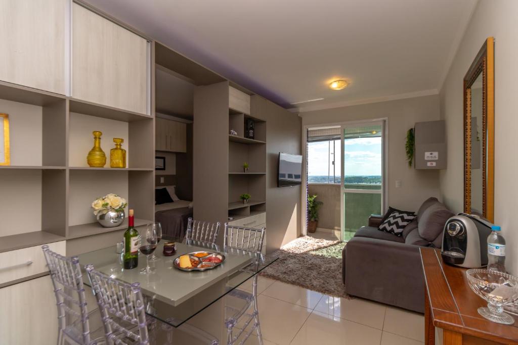 a kitchen and living room with a table and a couch at Pôr do sol 18º andar vista da cidade CENTRAL, Garagem NOVO in Passo Fundo
