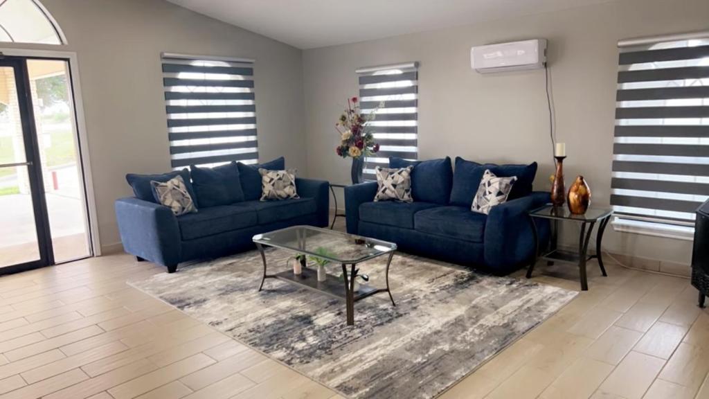 a living room with blue couches and a table at Falcon Executive Inn in Zapata