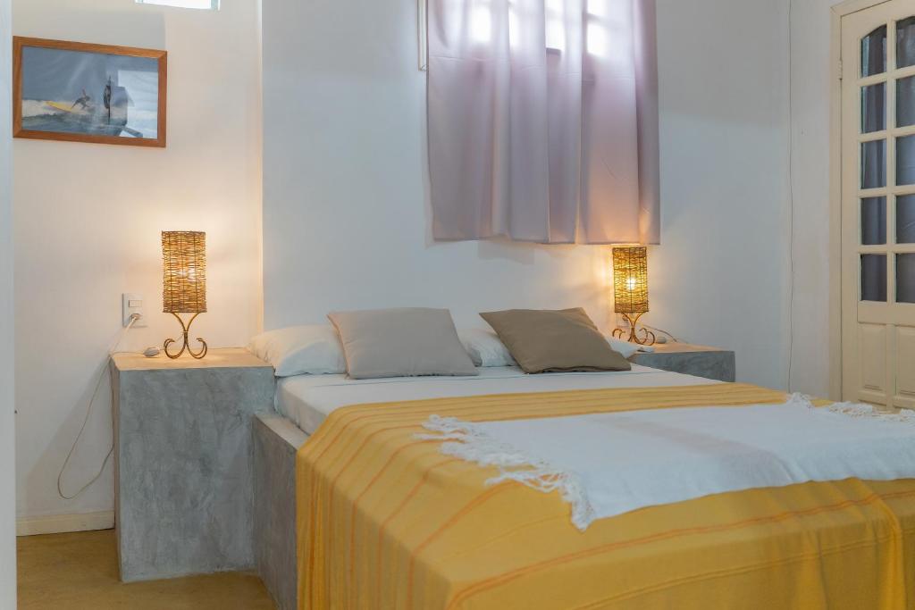 una camera con un grande letto con due lampade di casa jasmin a Jericoacoara