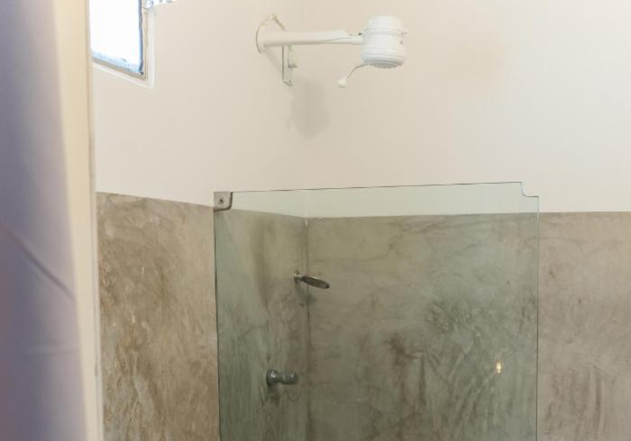 bagno con doccia e porta in vetro di casa jasmin a Jericoacoara
