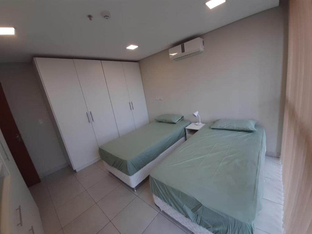 two beds in a small room with white cabinets at Miradores del Chaco in Asuncion