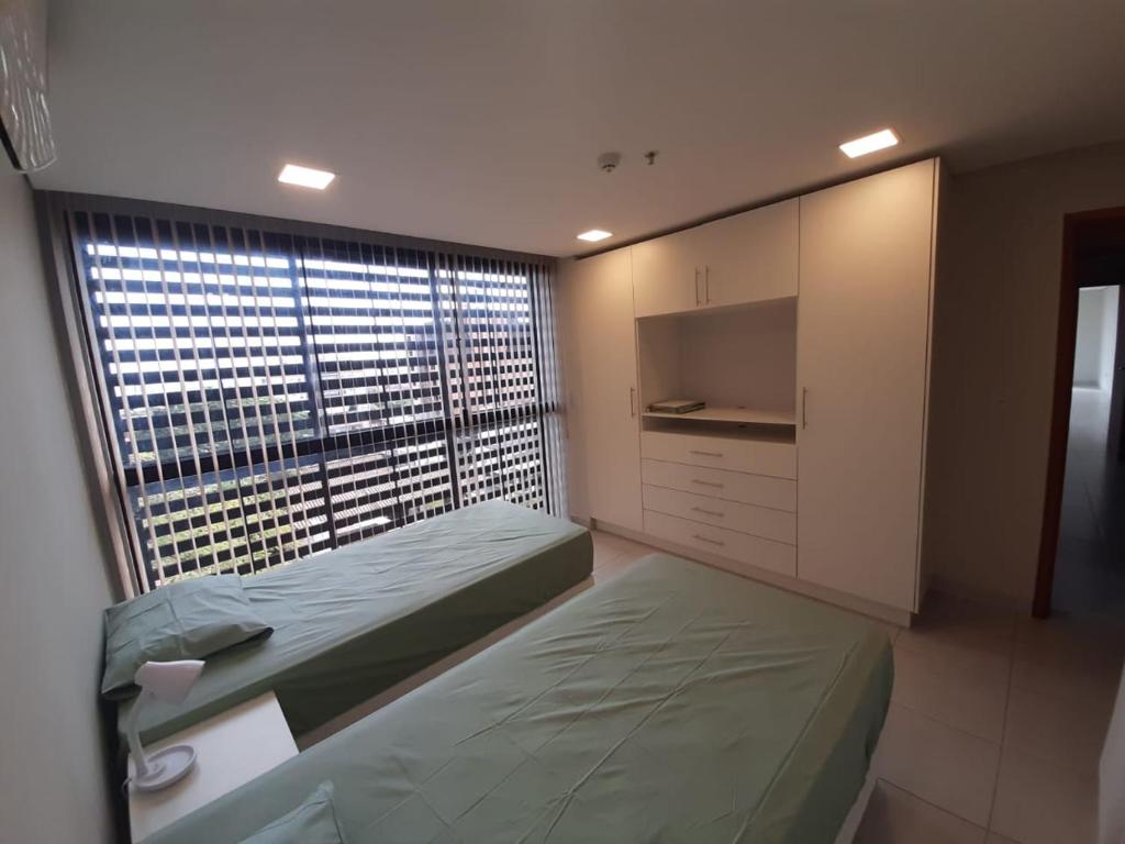 a bedroom with two beds and a large window at Miradores del Chaco in Asuncion