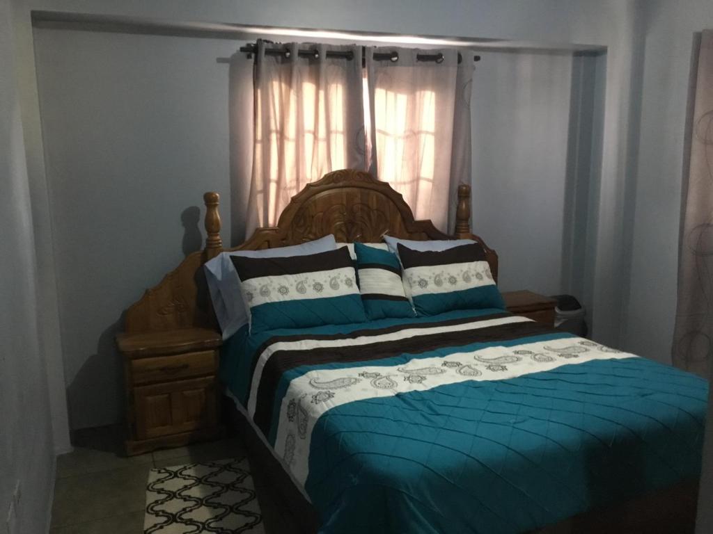 1 dormitorio con 1 cama con edredón azul y ventana en Foothills Apartment 28 Vacation Nest en San Fernando