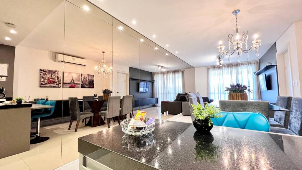 eine Küche und ein Wohnzimmer mit einem Esszimmer in der Unterkunft Viva em um Resort Paradisíaco na Brava 100m do Mar in Itajaí