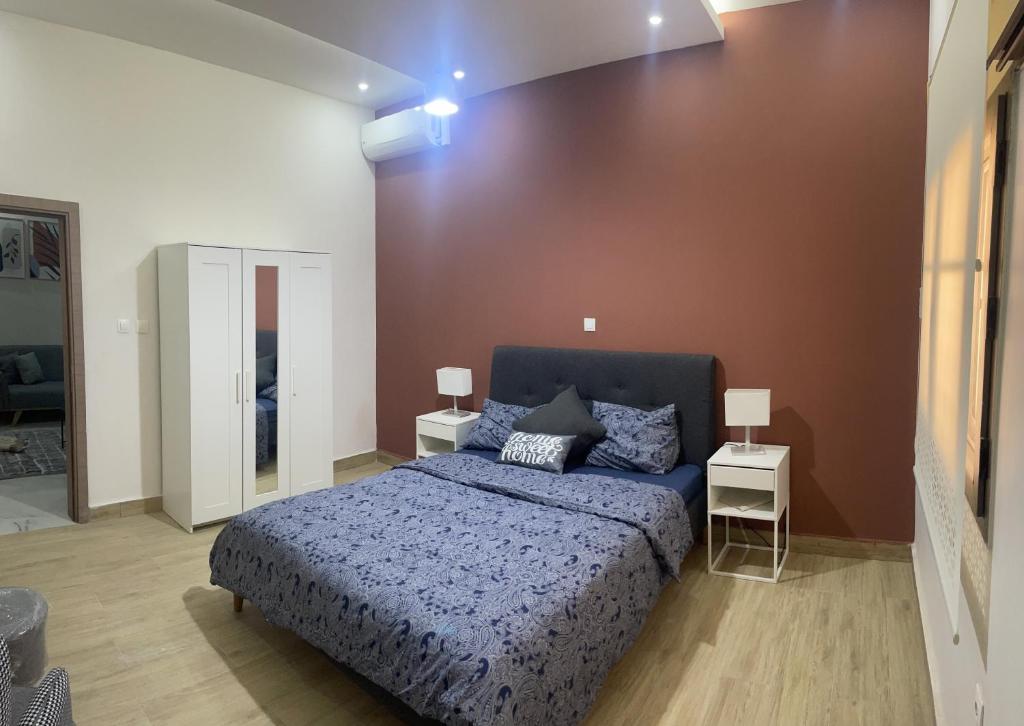 sypialnia z niebieskim łóżkiem i dwoma stołami w obiekcie résidence zeineb w mieście Nawakszut