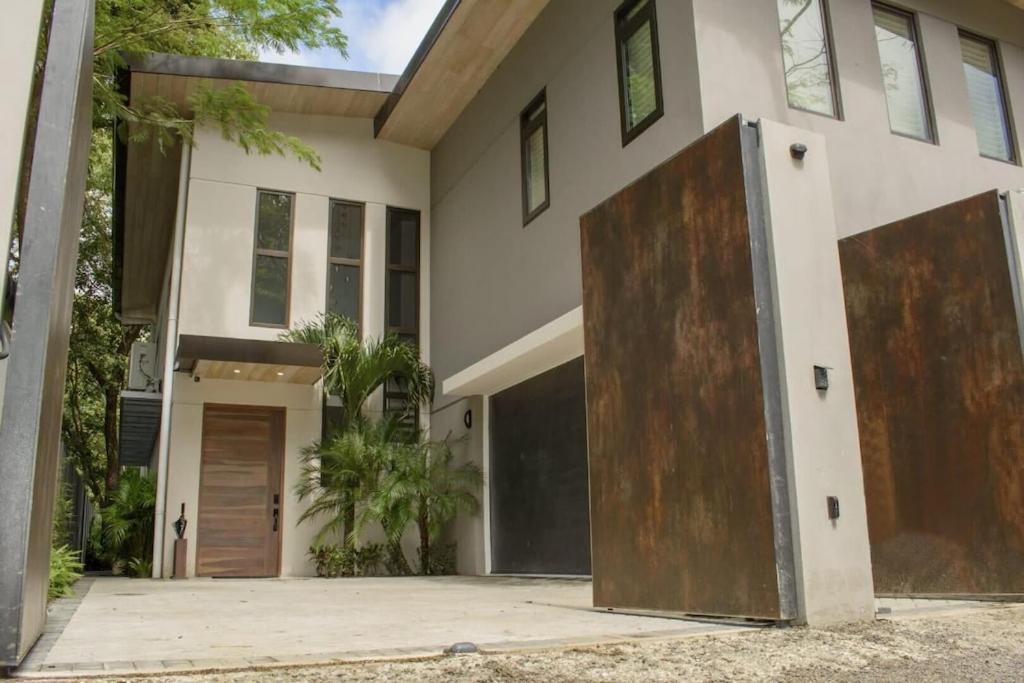 Cette grande maison blanche est dotée d'une grande porte en bois. dans l'établissement Casa Kaiman - Villa Azul, à Nosara