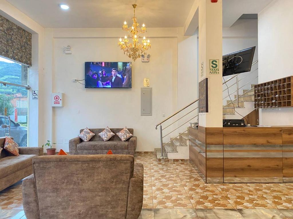 a living room with a couch and a tv on the wall at Hotel Los Pajonales in Huaraz