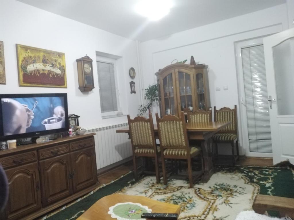 uma sala de estar com uma mesa de jantar e uma televisão em Kraljevski apartman em Kraljevo