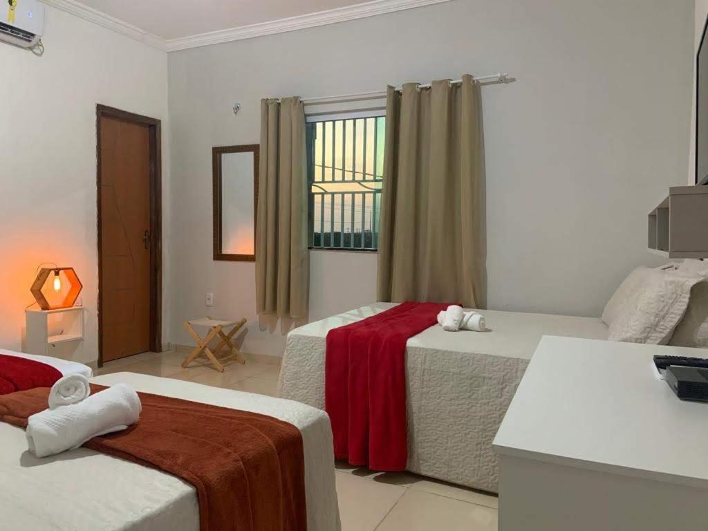 een hotelkamer met 2 bedden en een televisie bij Pousada Barreirinhas House in Barreirinhas