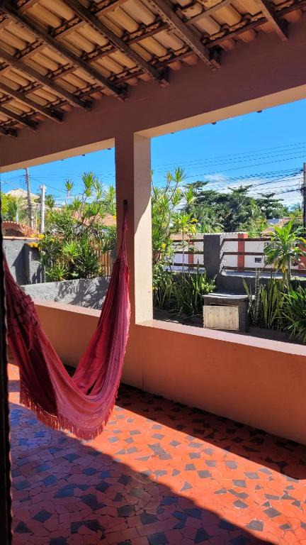a hammock in a room with a view of the ocean at Casa de Temporada - Solar Guest House in Saquarema
