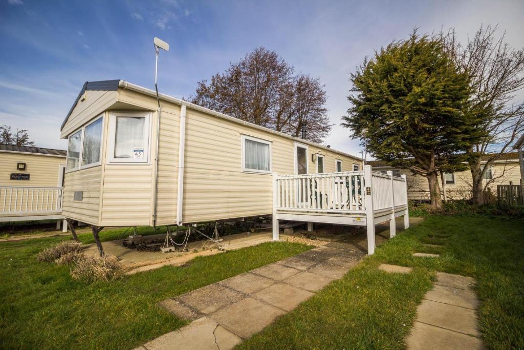 a mobile home with a porch and a house at Caravan With Decking At Manor Park In Hunstanton, Sleeps 6 Ref 23045b in Hunstanton