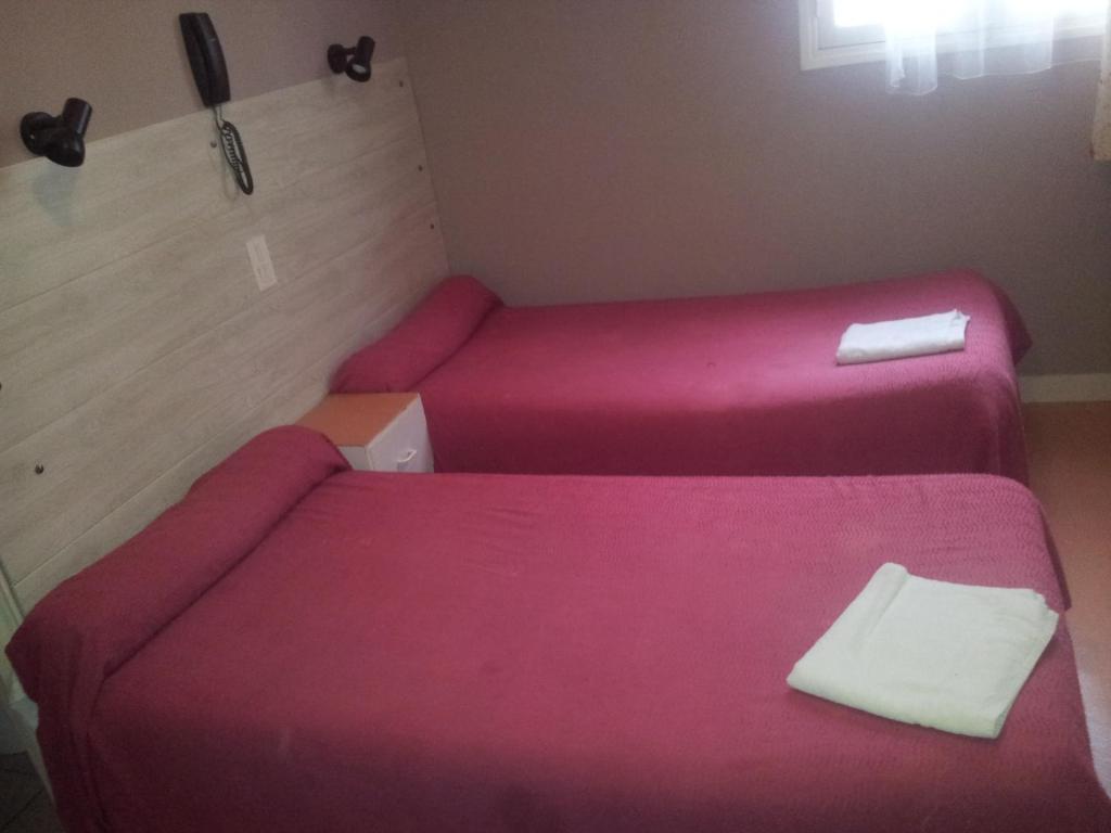 パリにあるオテル ドゥ テラージュの小さなお部屋で、ベッド2台(ピンクのシーツ付)が備わります。