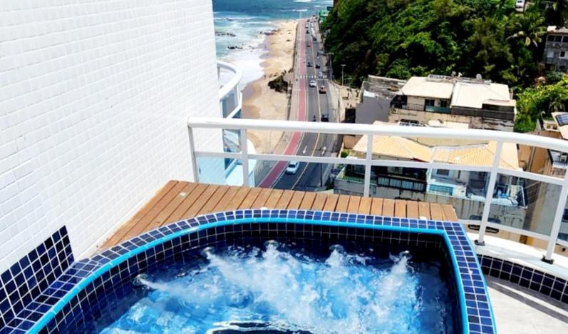 bañera de hidromasaje en el balcón con vistas al océano en Cobertura em Ondina, en Salvador