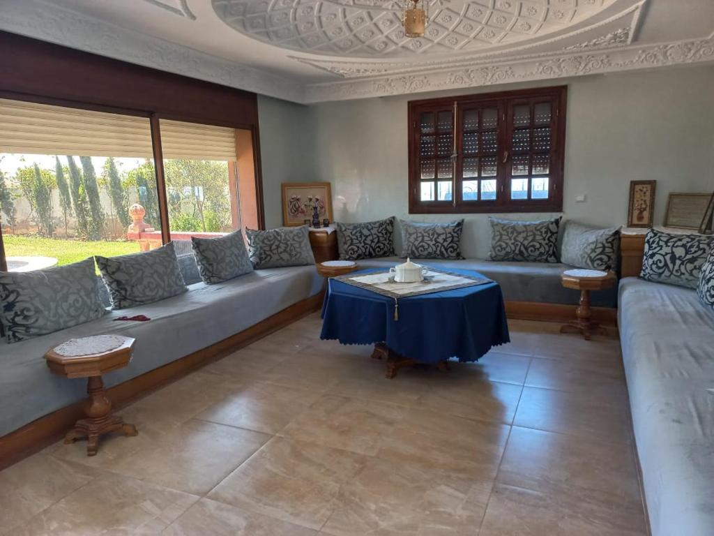 ein Wohnzimmer mit einem Sofa und einem Tisch in der Unterkunft Villa piscine bir jdid in Bir Jedíd Saint-Hubert