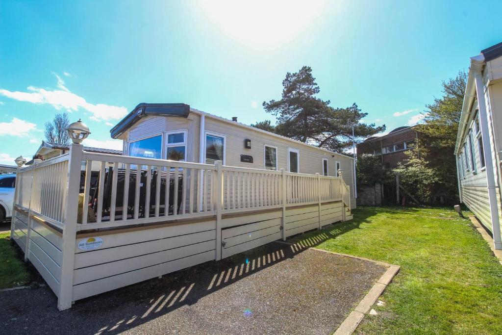 a mobile home with a white fence in a yard at Brilliant 8 Berth Caravan Near Walton-on-the-naze In Essex - 17023nm in Walton-on-the-Naze