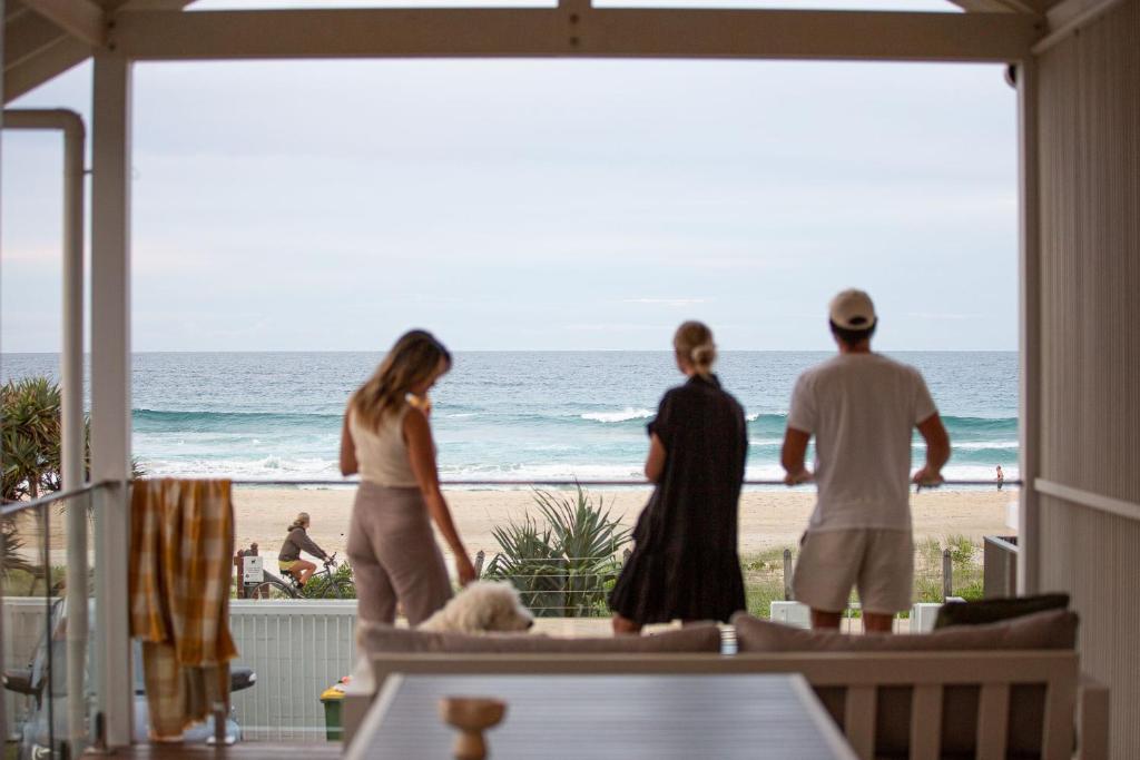 eine Gruppe von Menschen, die auf einer Veranda mit Blick auf den Strand stehen in der Unterkunft Rigi on Currumbin Beach in Gold Coast