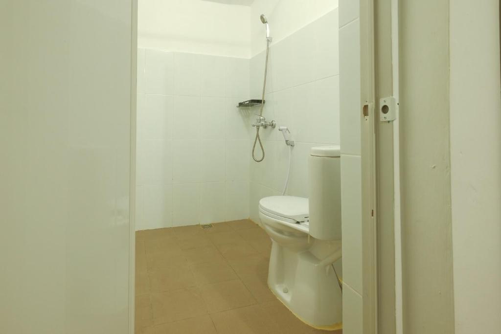 a bathroom with a toilet and a shower at Snooze Malang in Malang