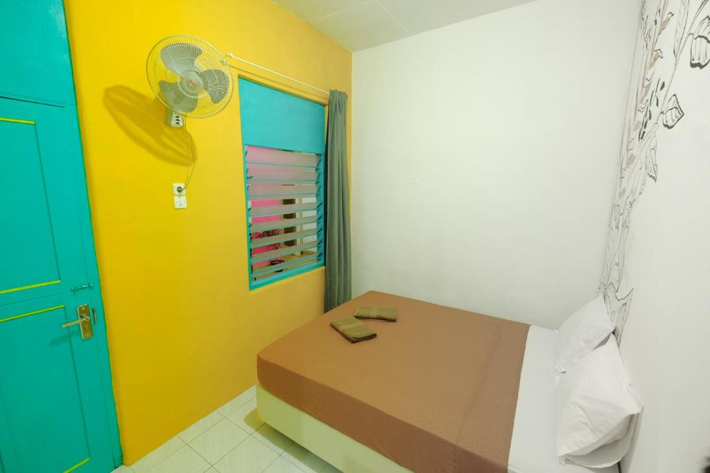 a room with a bed and a colorful door at Snooze Malang in Malang
