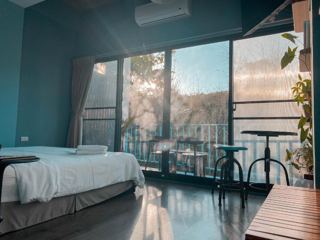 a bedroom with a bed and a large window at Lugo Hotel in Manzhou