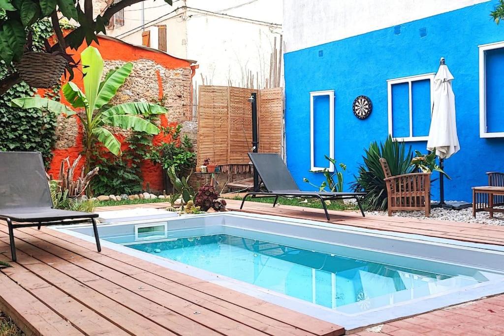 een zwembad in een achtertuin met een blauw gebouw bij Charmante petite villa avec piscine in Claira
