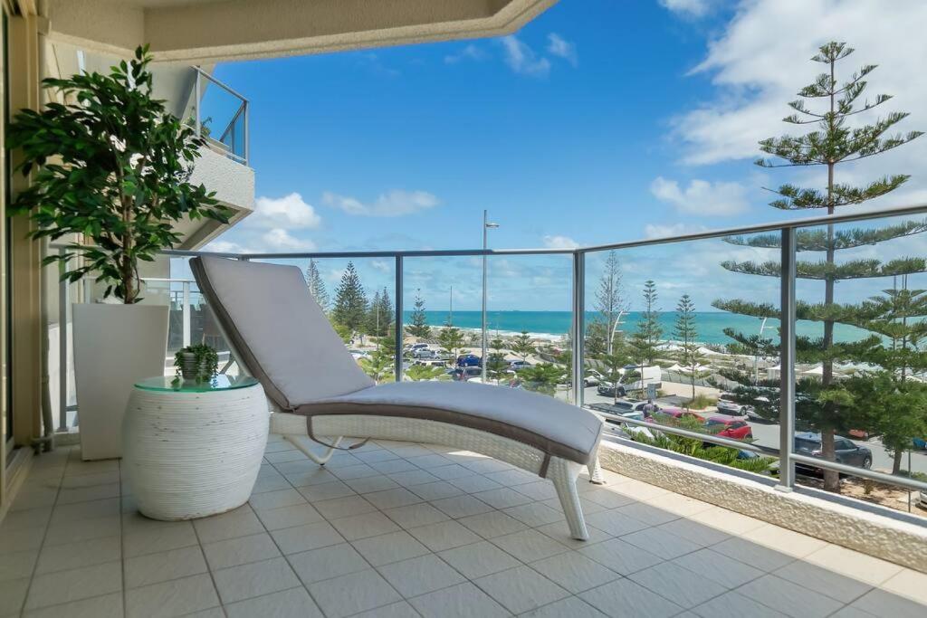 a white chair on a balcony with a view of the ocean at Suite 305 Sandcastles 3 Bedroom Deluxe Apartment in Perth