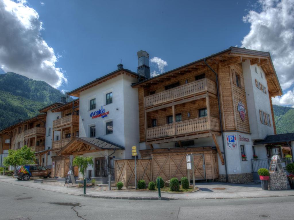 un edificio in montagna con un'auto parcheggiata di fronte di Kaprun Mountain Resort by Kaprun Rentals a Kaprun