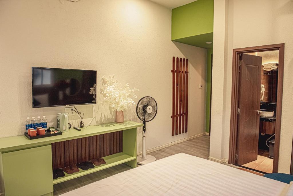 a bedroom with a bed and a tv on a wall at Villa Hoa Da in Da Lat