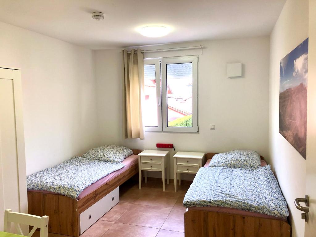 een kamer met 2 bedden en een raam bij Pension Chen, 2 Doppelzimmer , EBK, separater Balkon in Griesstätt