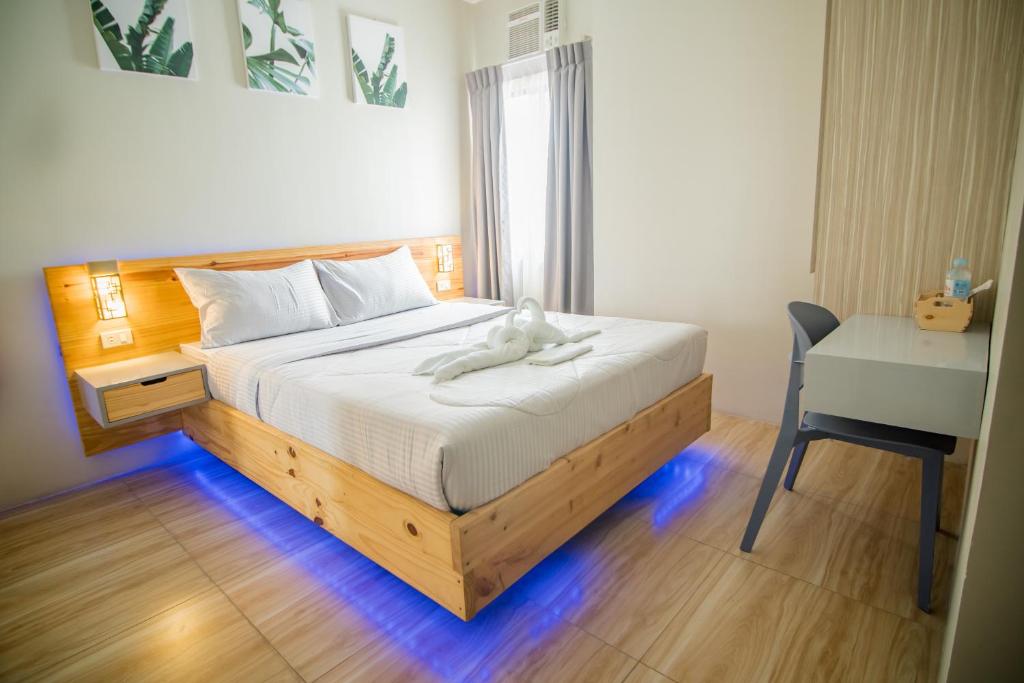 a bedroom with a bed with a white stuffed animal on it at DLT Suites Boutique Hotel in Minglanilla