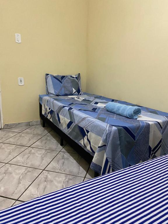 a bedroom with a bed with a blue comforter at Apartamento em frente Basílica in Aparecida